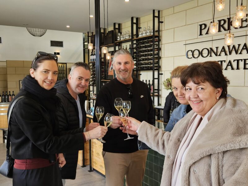 Happy guests toasting with sparkling wine inside Parker Coonawarra Estate cellar door.