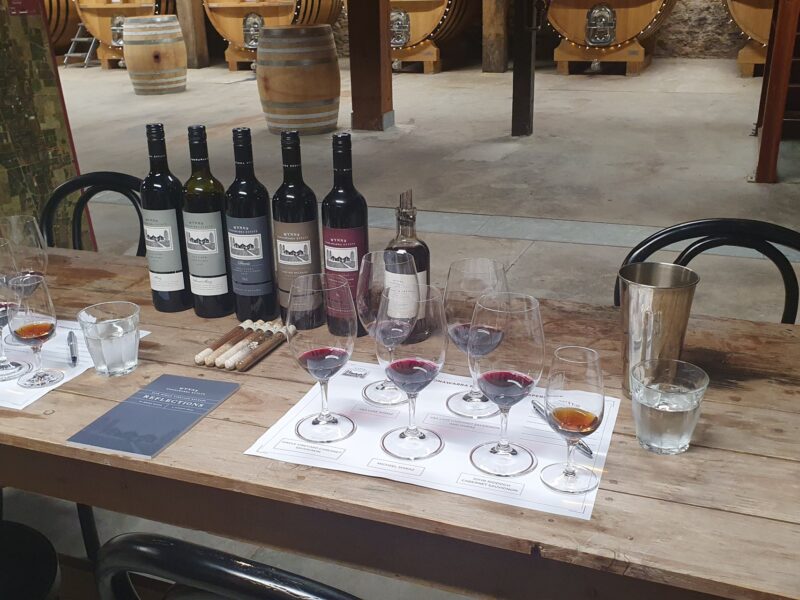 Close-up of a wine tasting setup at Wynns Coonawarra Estate, with red wines, fortified wine, bottles, and tasting notes.