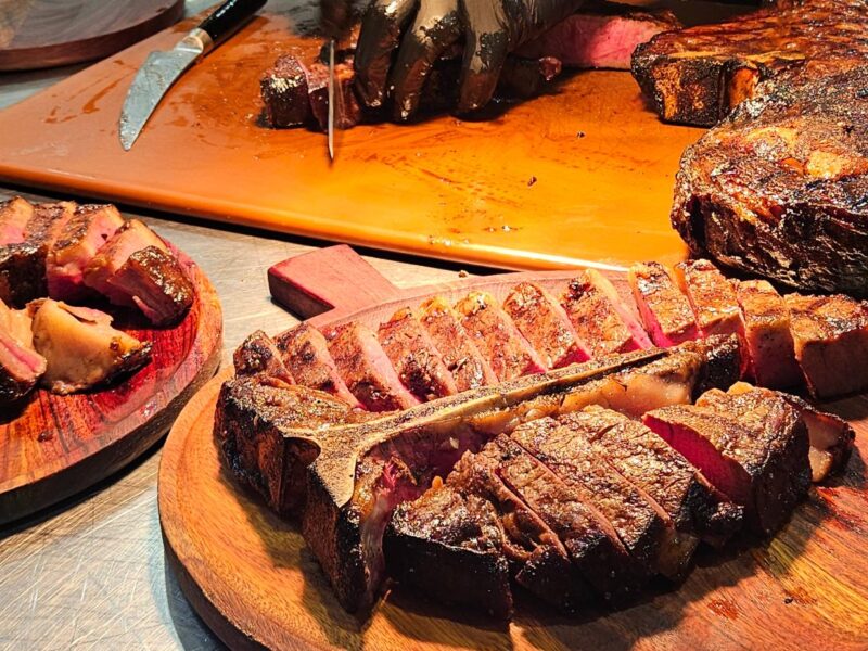 Coonawarra Experiences – Chef carving wagyu tomahawk with sliced beef on boards.