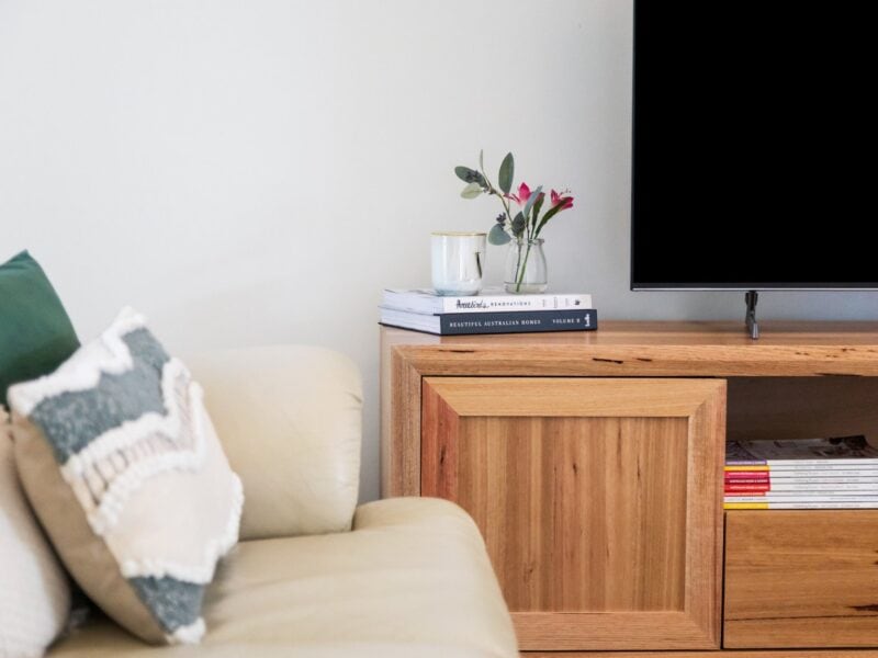 Coonawarra Experiences – Cozy lounge detail with sofa, TV, books, and fresh flowers.