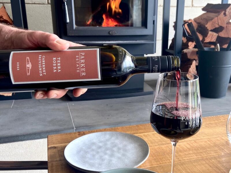 Parker Estate Terra Rossa Cabernet label close up with wine pour and osso bucco beside wood fire