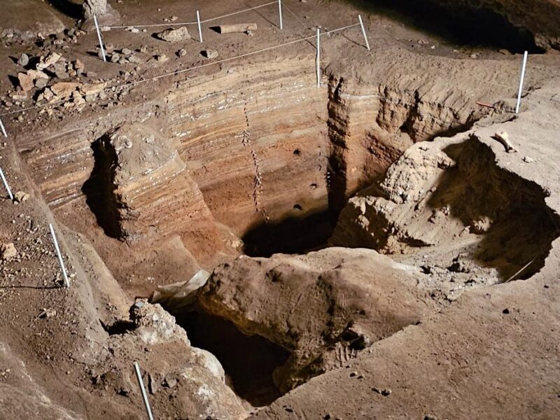 An excavation pit inside Naracoorte Caves, surrounded by a safety barrier.