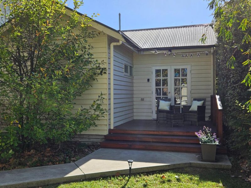 Coonawarra Experiences private guest accommodation entrance with deck and outdoor seating in leafy garden setting.