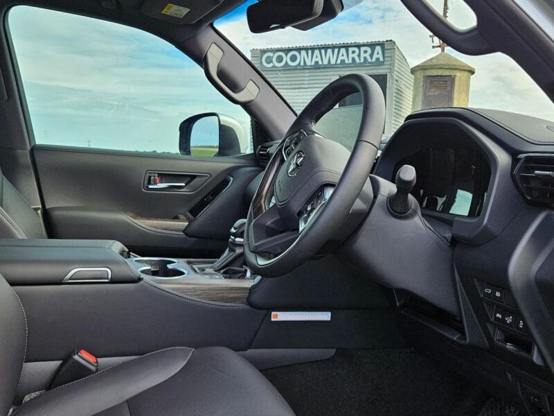 Driver’s seat interior of LandCruiser with Coonawarra siding visible through window