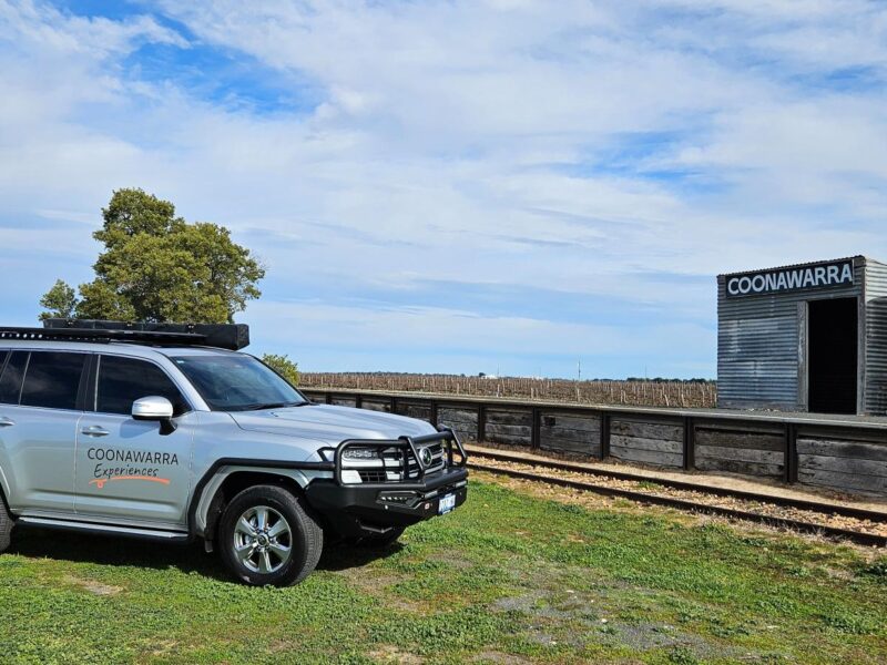 Toyota LandCruiser in front of old Coonawarra station and vineyard rows