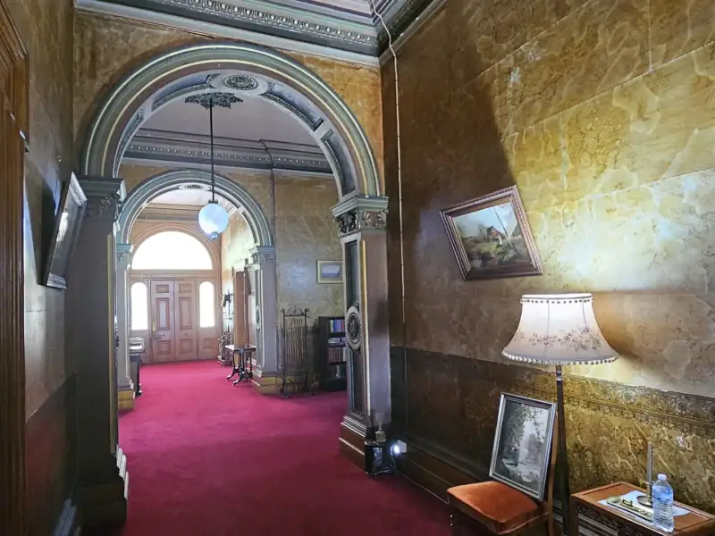Entrance hallway at Yallum Park with marbled walls, archways and original carpet runner
