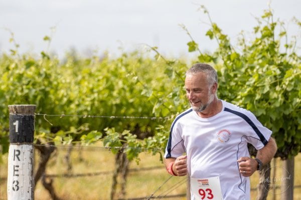 Runner wearing a race bib on the Coonawarra Running Festival course beside the vineyards
